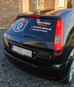 Plakletters naast sticker op achterruit auto